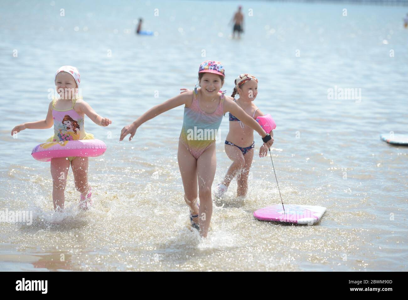 LA PERMISSION PARENTALE A ÉTÉ ACCORDÉE à trois jeunes filles qui profitent du beau temps sur la plage de Southend-on-Sea dans l'Essex, car le public est rappelé à pratiquer la distanciation sociale après le relâchement des restrictions de verrouillage en Angleterre. Banque D'Images