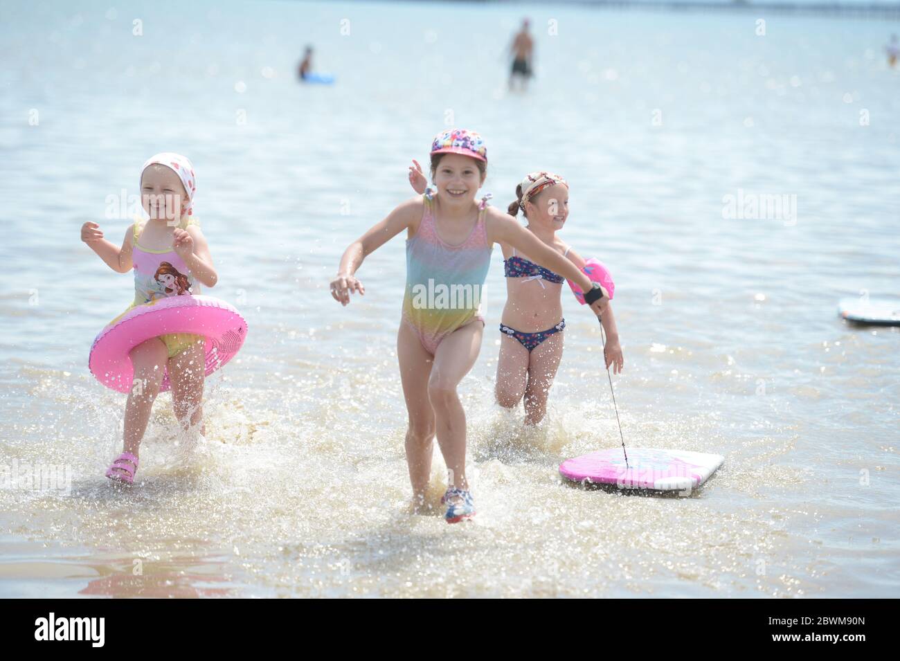 LA PERMISSION PARENTALE A ÉTÉ ACCORDÉE à trois jeunes filles qui profitent du beau temps sur la plage de Southend-on-Sea dans l'Essex, car le public est rappelé à pratiquer la distanciation sociale après le relâchement des restrictions de verrouillage en Angleterre. Banque D'Images