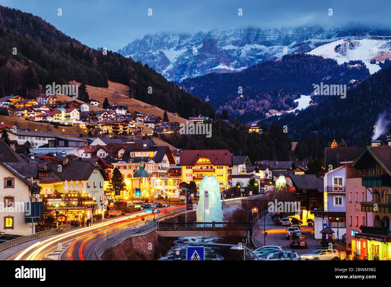 Val Gardena, Italie. Soirée sur la station balnéaire populaire de Val Gardena, Italie. Dolomites alpes montagnes au coucher du soleil. Hôtels, cafés et repos éclairés Banque D'Images