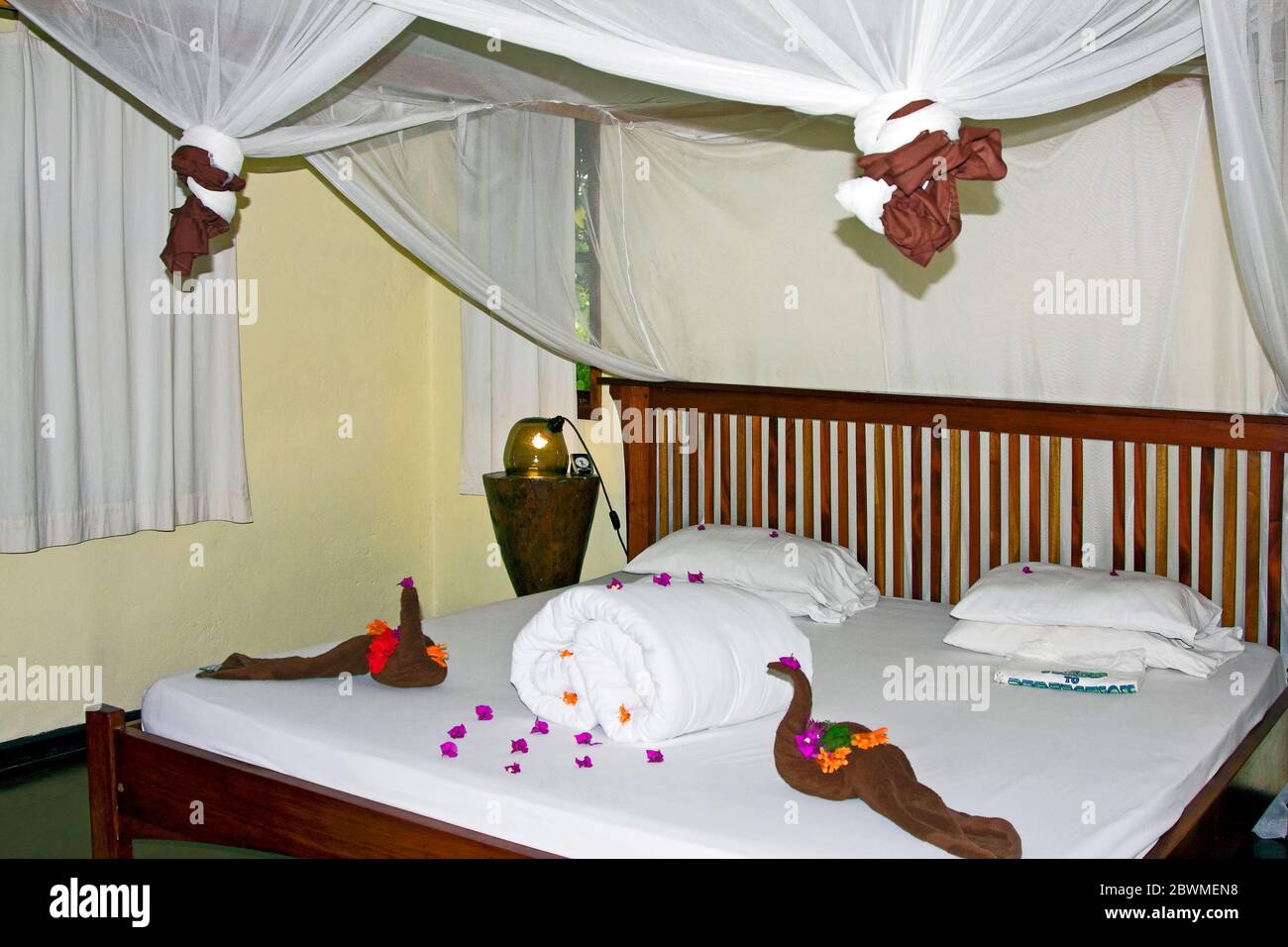 Intérieur de chalet, lit king size, pétales de fleurs, serviettes en forme de forme, moustiquaire attachée; hébergement safari; Moi Varo Lodge; Afrique, Arusha; Tanzanie Banque D'Images