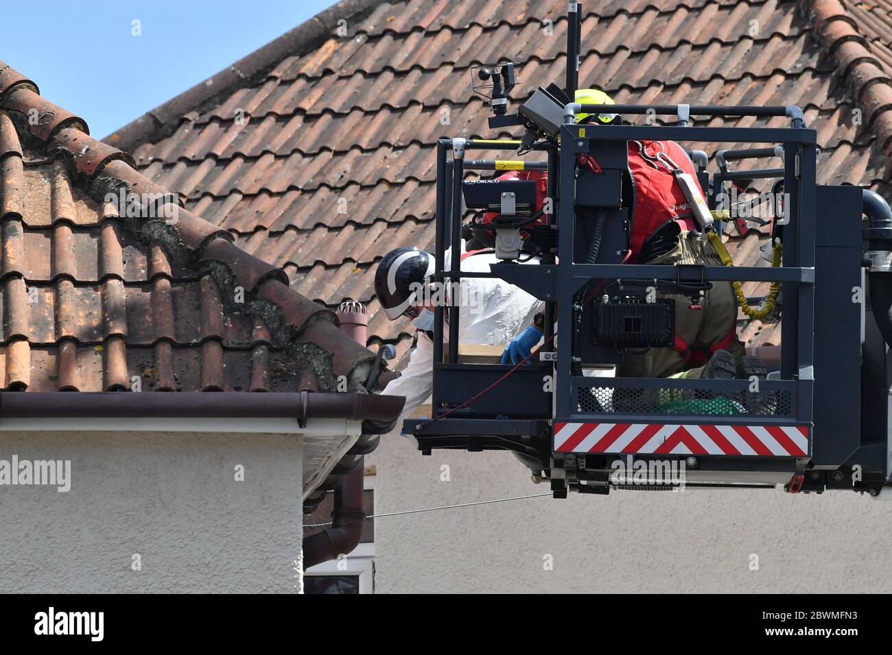 Une scène d'officier de crime inspecte la gouttière à partir d'une plate-forme aérienne, exploitée par les pompiers, à l'extérieur d'une maison sur le chemin Wessex à Salisbury, Wiltshire, où deux femmes sont mortes à la suite d'une perturbation lundi. Un homme dans ses années 30 a été arrêté pour meurtre et placé en détention au commissariat de police de Melksham. Banque D'Images