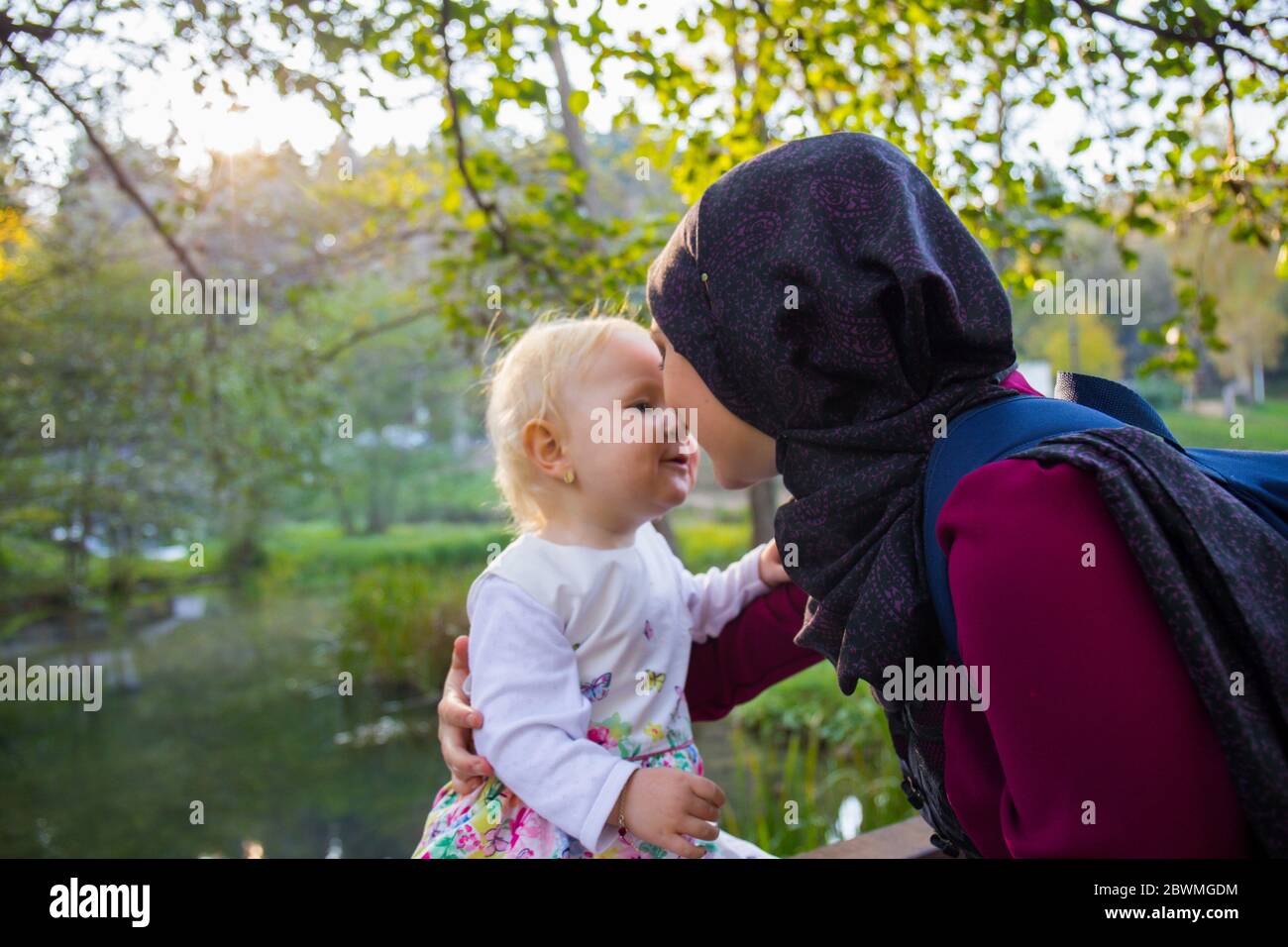 Maman et bébé appréciant la nature, automne sec, jour ensoleillé, marche dans la prairie en robes, collecte des feuilles tombées Banque D'Images