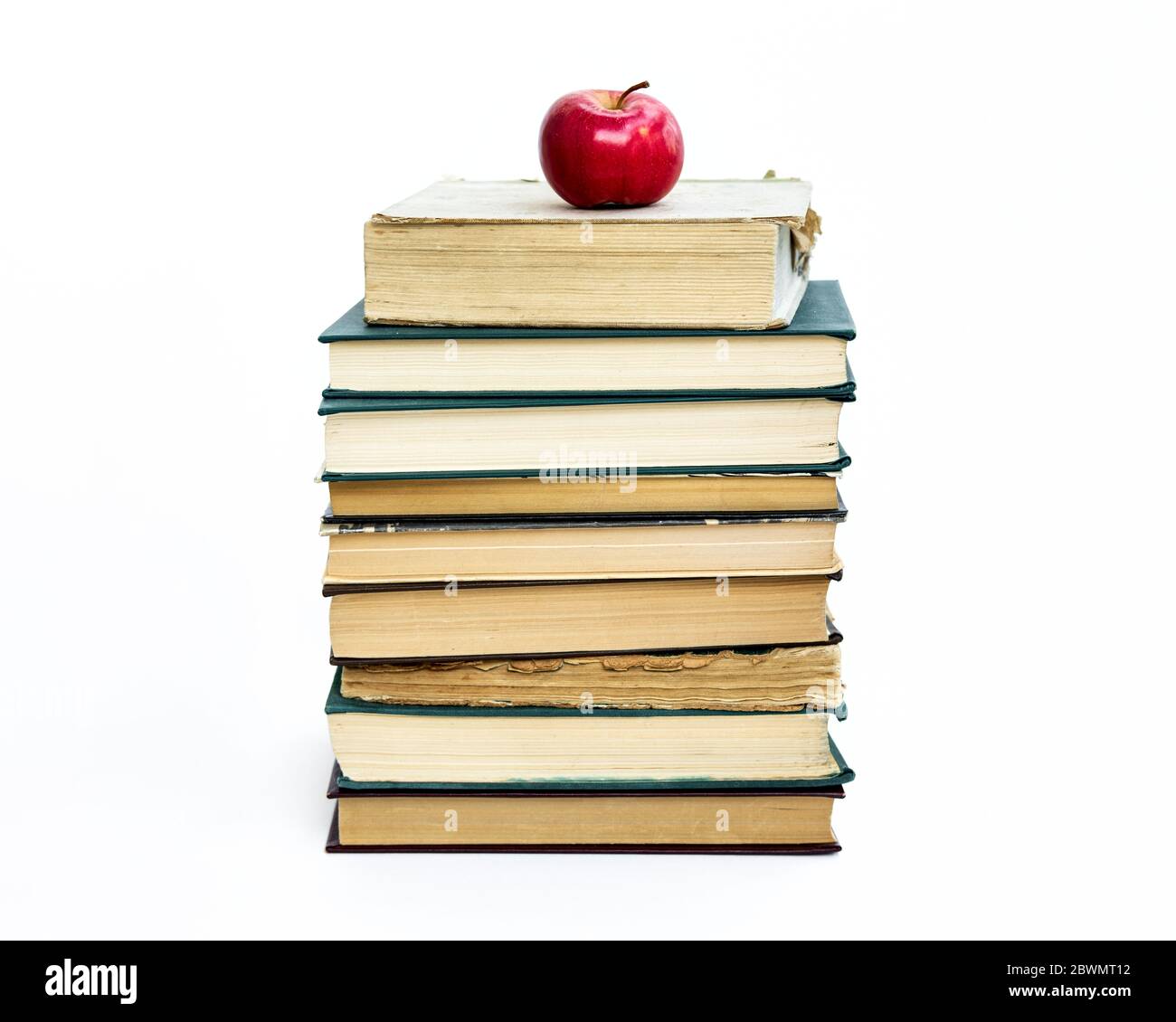 une pile de vieux livres. Une pomme rouge se trouve sur le dessus. Le concept d'une idée est venu comme une pomme de Newton. Sur fond blanc Banque D'Images