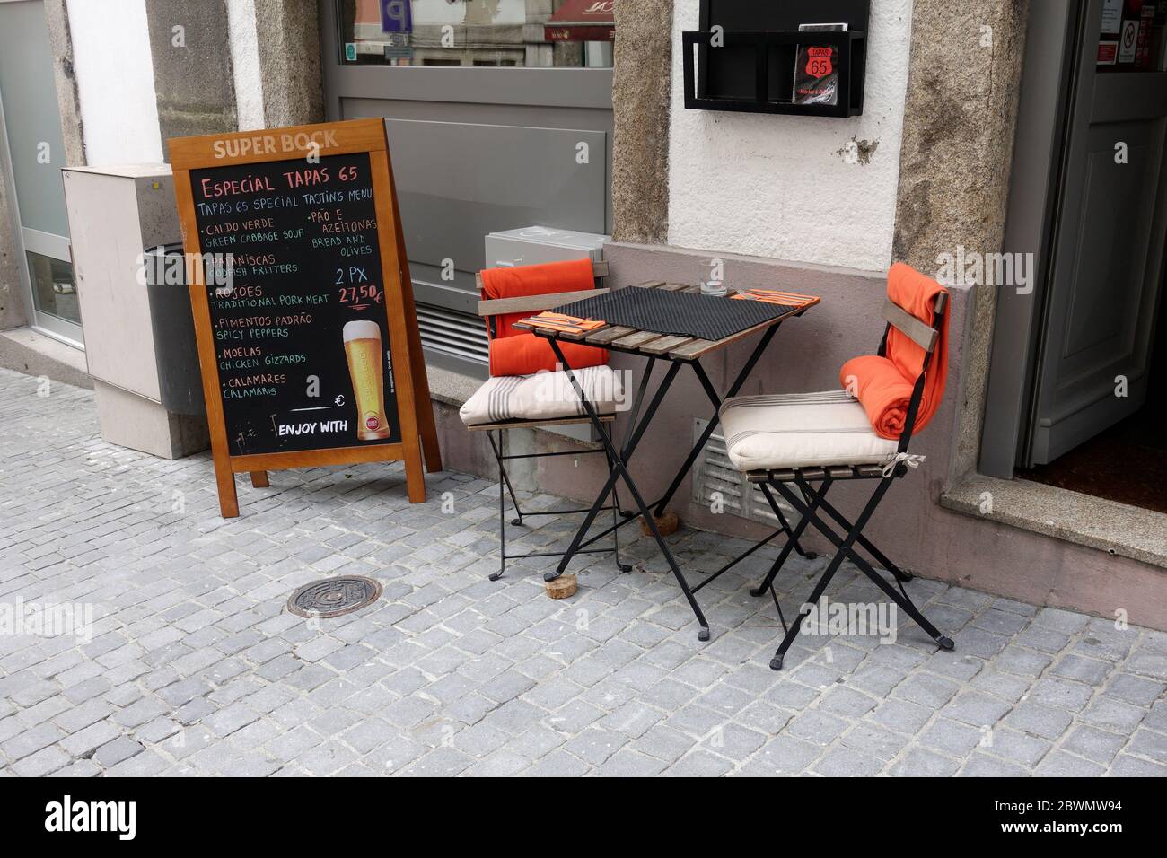 Tiny Sidewalk Cafe Bar Restaurant Table pour deux à manger à l'extérieur à Porto Portugal a UN menu de tableau de craie pour la bière et les tapas Banque D'Images