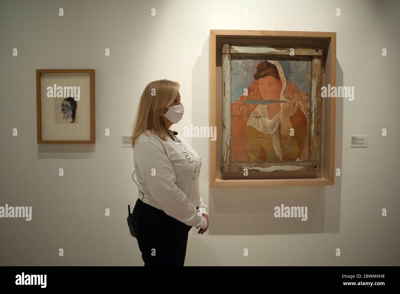 Une femme portant un masque facial se tient a cote d une peinture exposee pendant l exposition Dialogues avec Picasso Collection 2020 2023 au Musee Picasso. La nouvelle collection permanente arrive au...