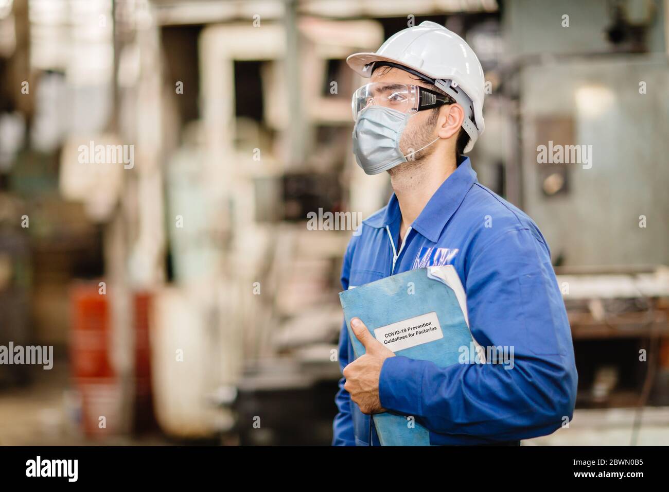 Travailleur portant un écran facial ou un masque jetable avec coronavirus(Covid-19) Guide de prévention Manuel de manuel pour la règle d'orientation pour un travail sain Banque D'Images
