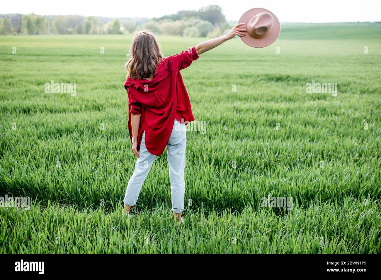 Femme élégante profitant du printemps et de la nature sur le terrain de verdure, vue arrière. Concept de vie et de liberté sans souci Banque D'Images