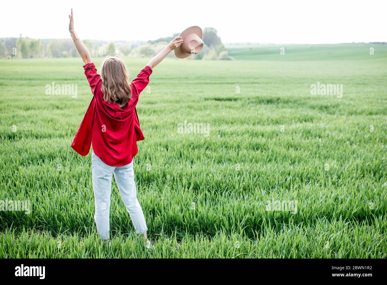 Femme élégante profitant du printemps et de la nature sur le terrain de verdure, vue arrière. Concept de vie et de liberté sans souci Banque D'Images