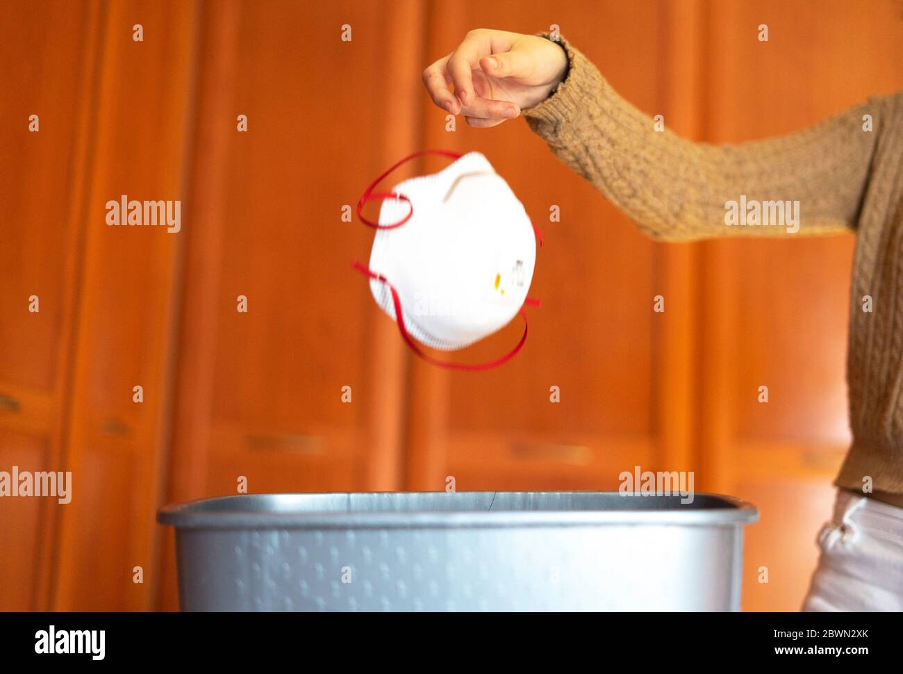 Femme jetant le masque dans la poubelle. Fin du concept COVID-19. Banque D'Images