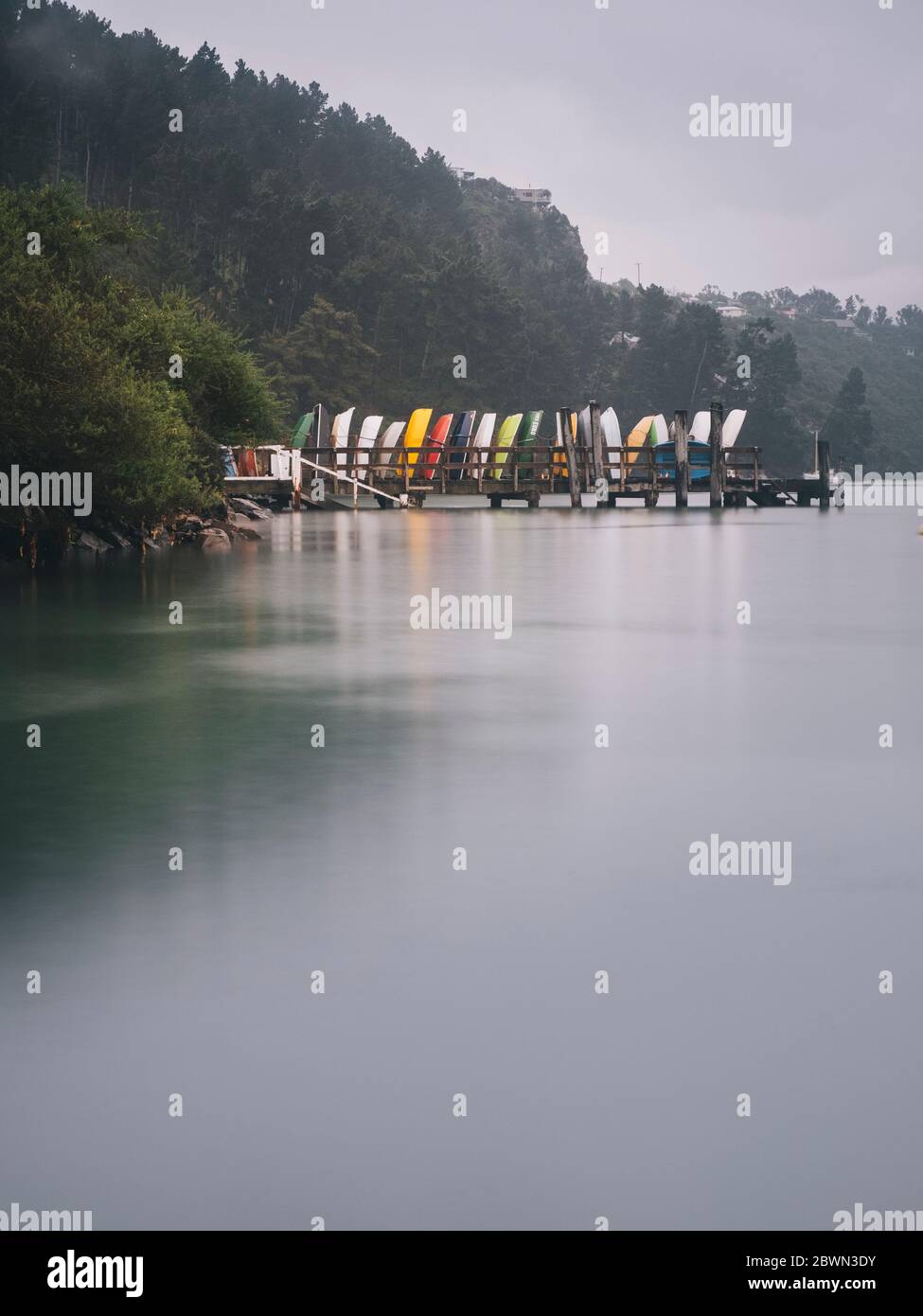 Purau Bay des bateaux colorés sur une jetée par une journée nuageux, péninsule de Banks, Nouvelle-Zélande Banque D'Images