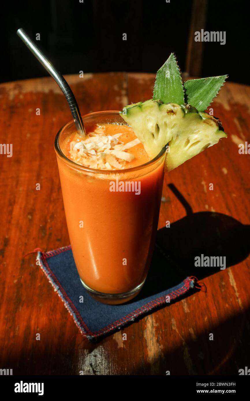 Smoothie papaye en verre sur table dans un café tropical Banque D'Images