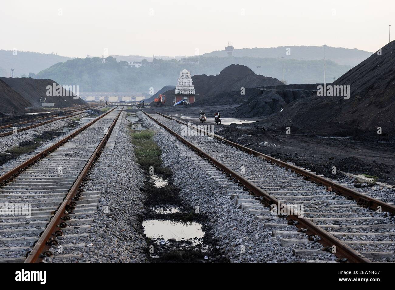 INDE Andhra Pradesh, Visakhapatnam, lieu de chargement du charbon importé d'Australie sur wagon ferroviaire pour le transport vers les usines sidérurgiques, temple hindou smal sur la voie ferrée Banque D'Images