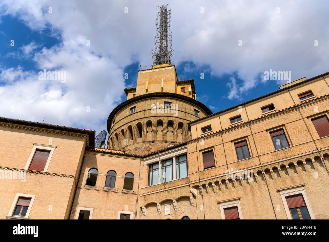 Tour de radio du Vatican - vue rapprochée à angle bas du bâtiment de radio du Vatican et de ses grands mâts de radio, contre les nuages blancs et le ciel bleu, Cité du Vatican, Rome. Banque D'Images