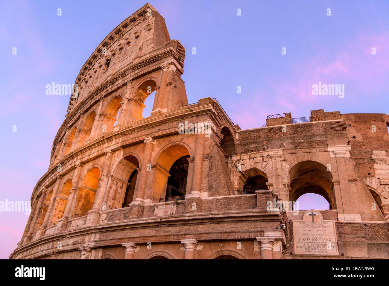 Sunset Colosseum - VUE rapprochée sur le coucher du soleil de la partie supérieure du mur extérieur ouest du Colisée, contre le ciel coloré du soir. Rome, Italie. Banque D'Images