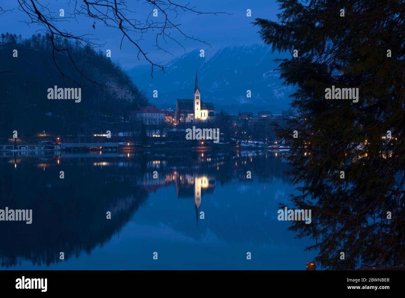 Église avec lumières sur le lac de montagne la nuit Banque D'Images