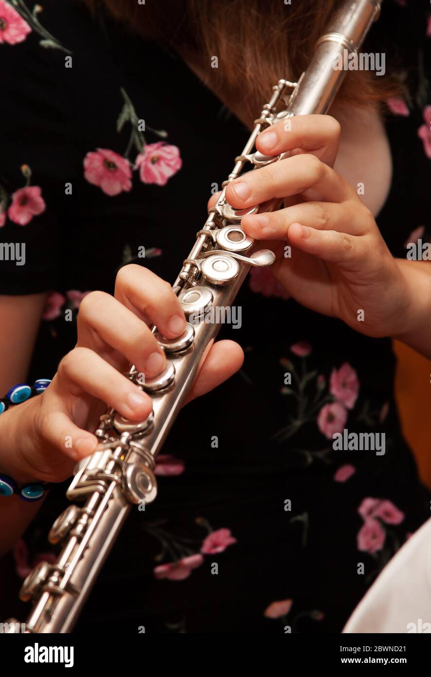 Flûtiste, jeune fille jouant la flûte, mains, doigts sur les clés gros plan, enfants jouant la flûte à sauter transversale, détail tourné, musique classique Banque D'Images