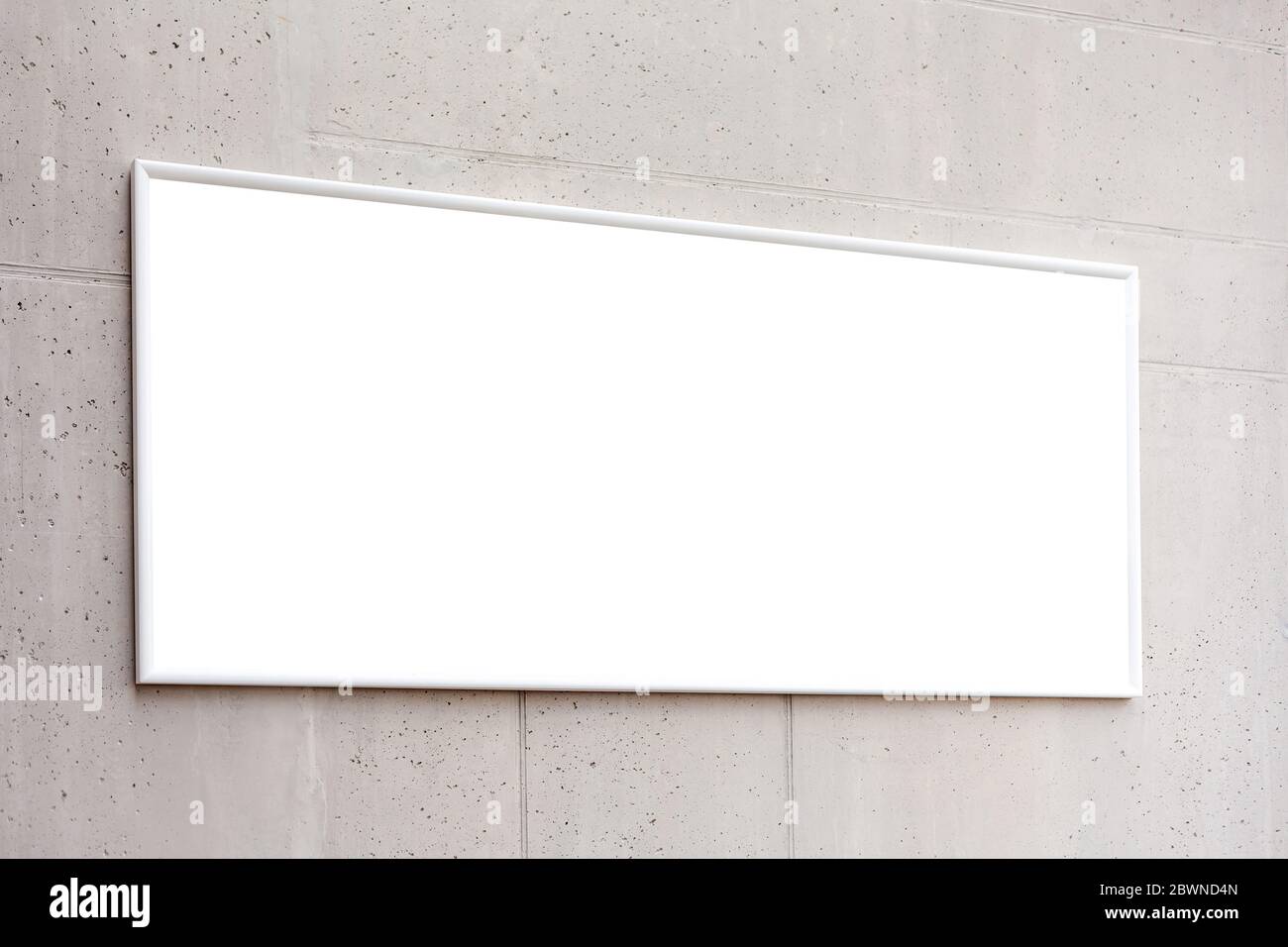 Cadre blanc d'affiche de horzontal blanc, publicité de bannière vide sur un mur de béton gris à l'intérieur du bâtiment, espace pour votre texte de fermeture, entreprise Banque D'Images