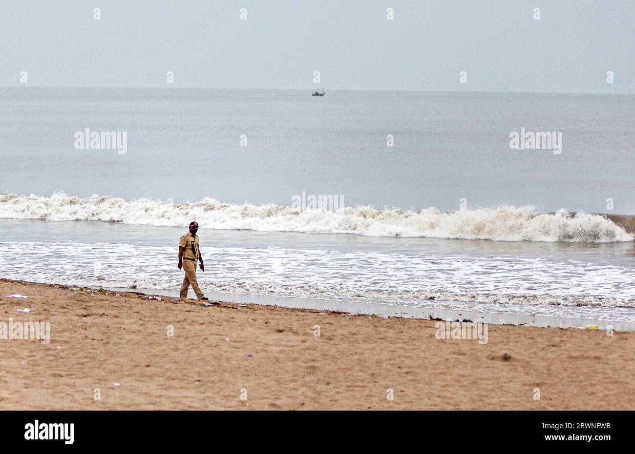 Un policier patrouille la plage en préparation du cyclone.le département météorologique indien (IMD) indique que le cyclone tropical Nisarga se dirige vers la côte du Maharashtra. Il a été conseillé aux gens de rester à l'intérieur, de se préparer à faire face à d'éventuelles coupures de courant, car de forts vents frappent la ville. La Force nationale d'intervention en cas de catastrophe (NDRF) a placé neuf équipes dans les districts vulnérables. Banque D'Images