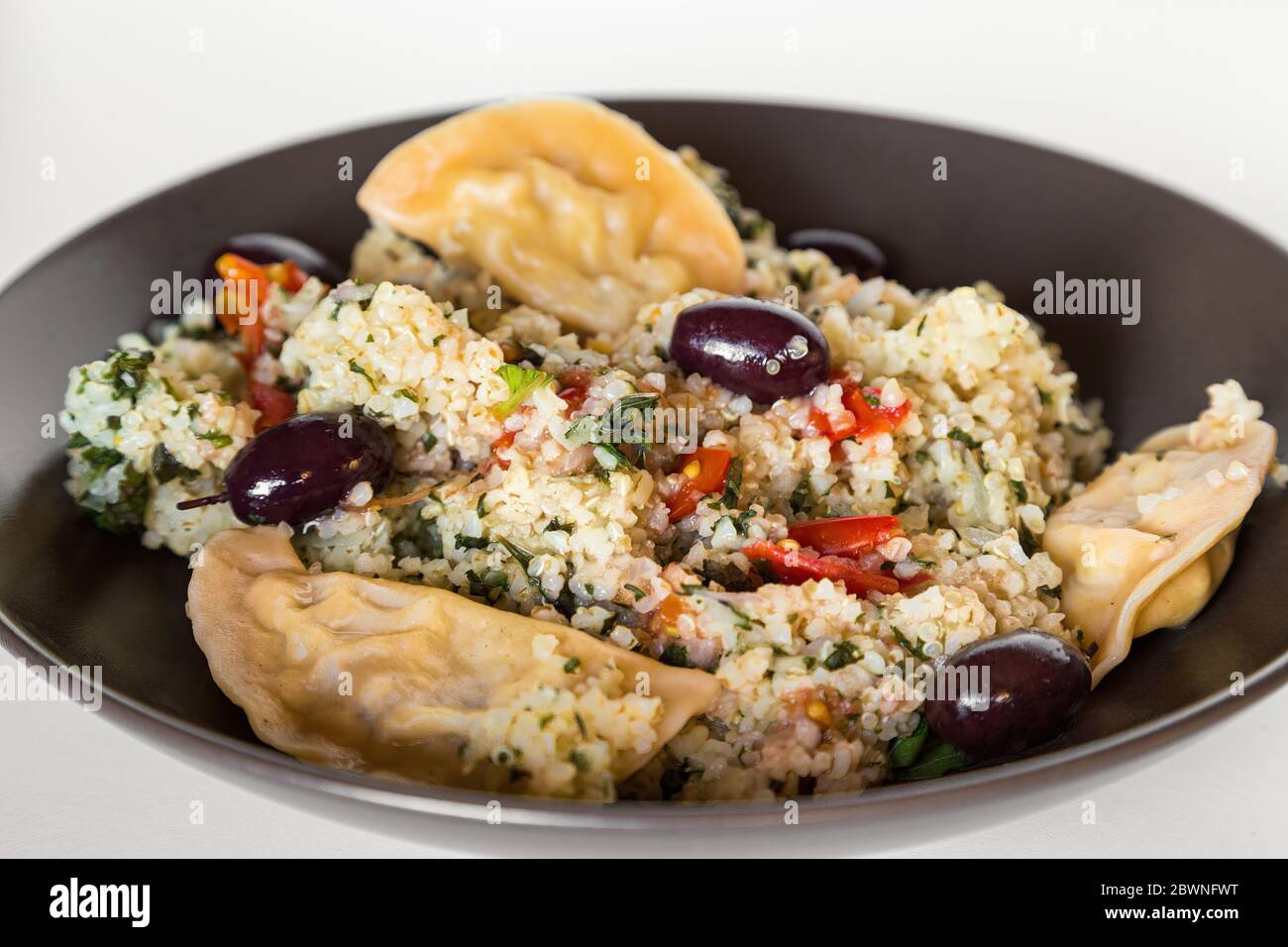 Bol de Bulgur de quinoa sain avec boulettes et olives noires Banque D'Images