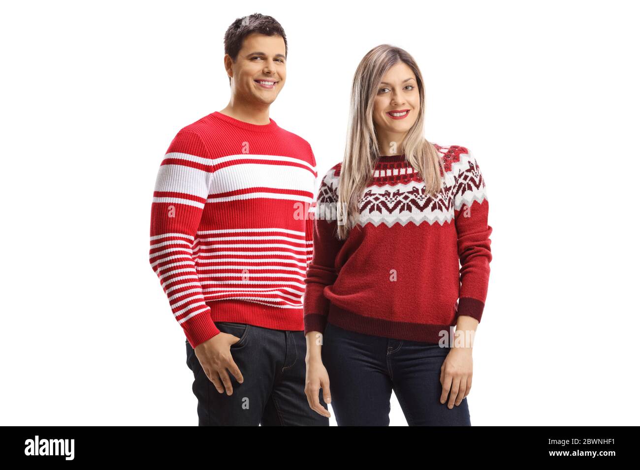 Couple portant des chandails rouges de noël et posant isolé sur fond blanc Banque D'Images