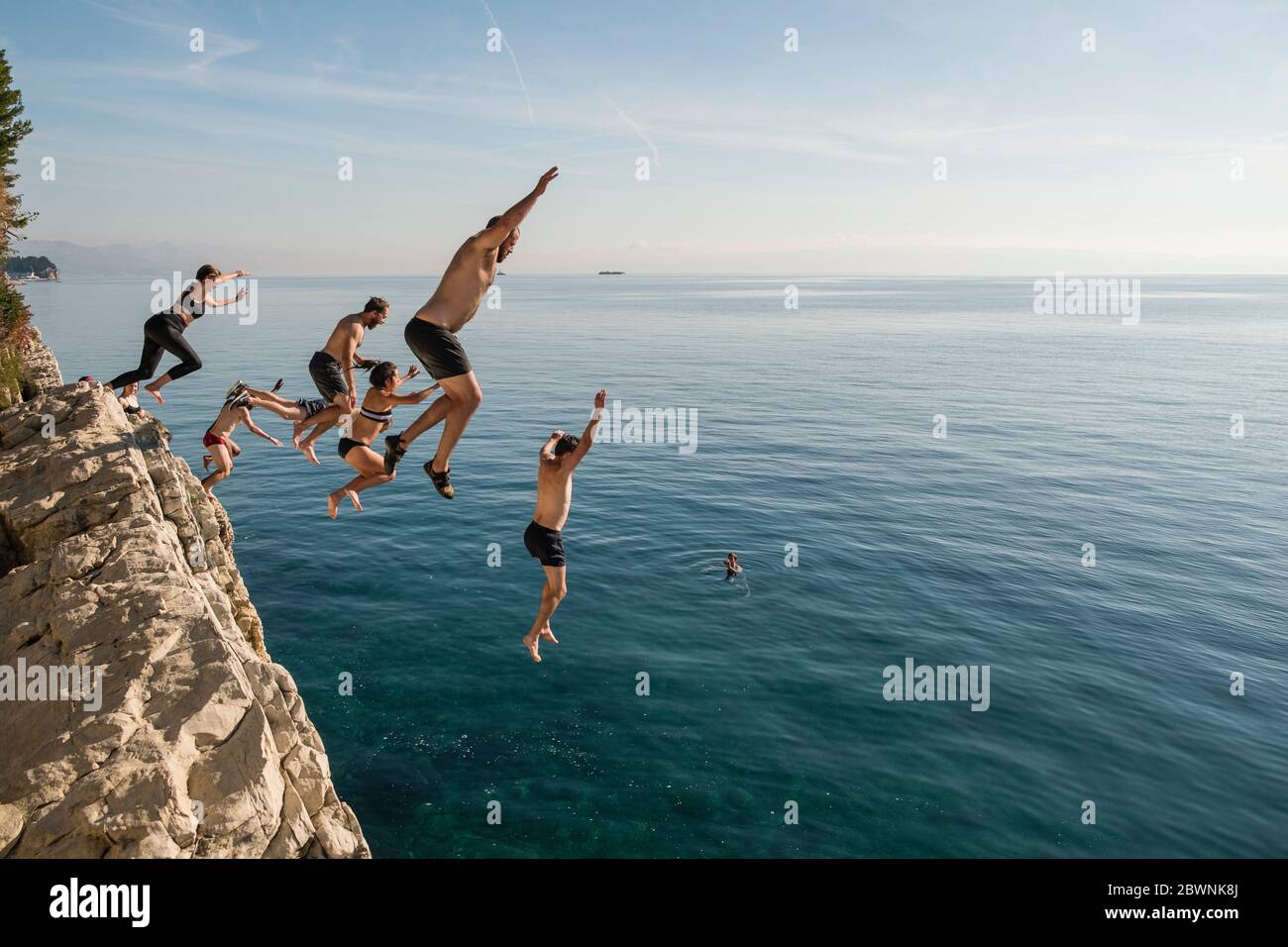 Amis qui sautent de la falaise dans la mer Adriatique près de Split, Croatie Banque D'Images