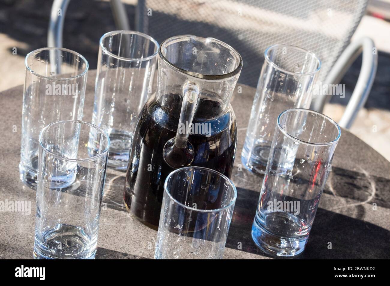 Vin croate fait maison dans une carafe de service avec 6 verres vides Banque D'Images