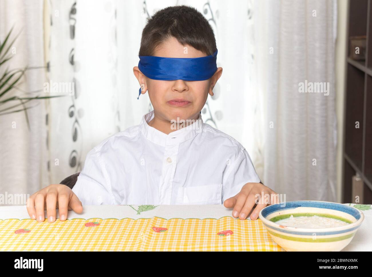 Geste de dégoût sur le visage d'un garçon de 8 ans après avoir fait un test de goût de nourriture. Banque D'Images