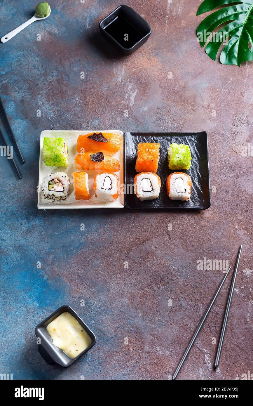 Ensemble de rouleau maki et de feuilles vertes de palmier sur table en pierre. Copier l'espace Banque D'Images