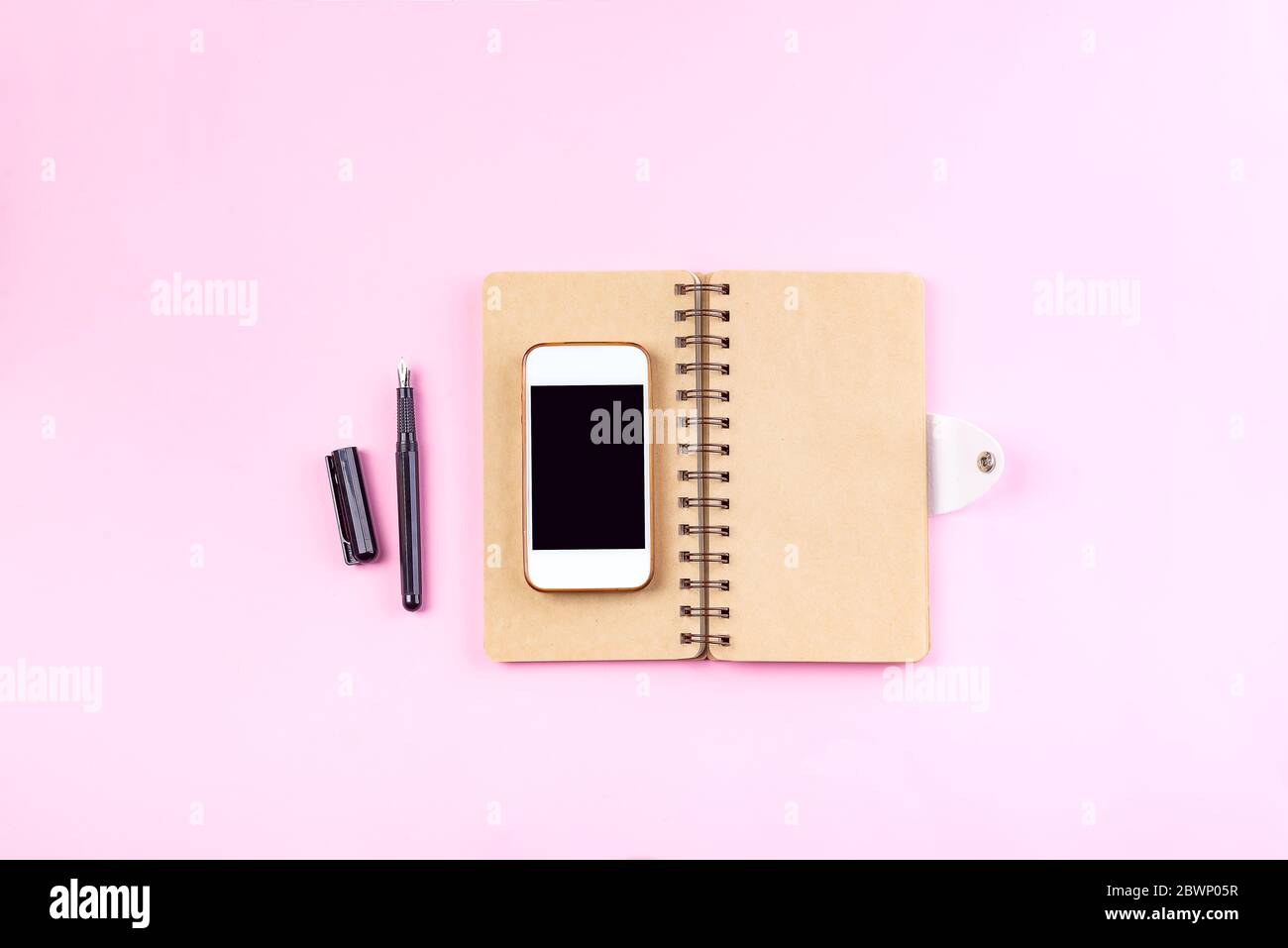 Ordinateurs portables Craft, stylo et smartphone sur fond rose pastel . Concept de maquette Banque D'Images