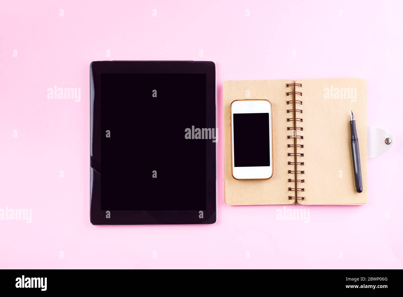 Ordinateurs portables, tablette, stylo et smartphone sur fond rose pastel . Concept de maquette pour les entreprises Banque D'Images