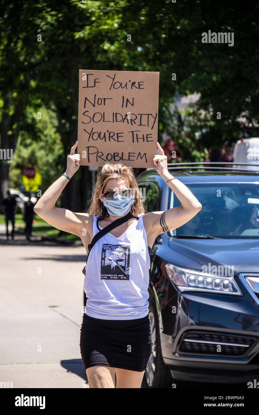 05-30-2020 Tulsa USA - une femme avec mini-jupe et F hommes t-shirt marche avec l'enseigne maintenue au-dessus de sa tête lecture si vous n'êtes pas dans la solidarité vous êtes la proble Banque D'Images