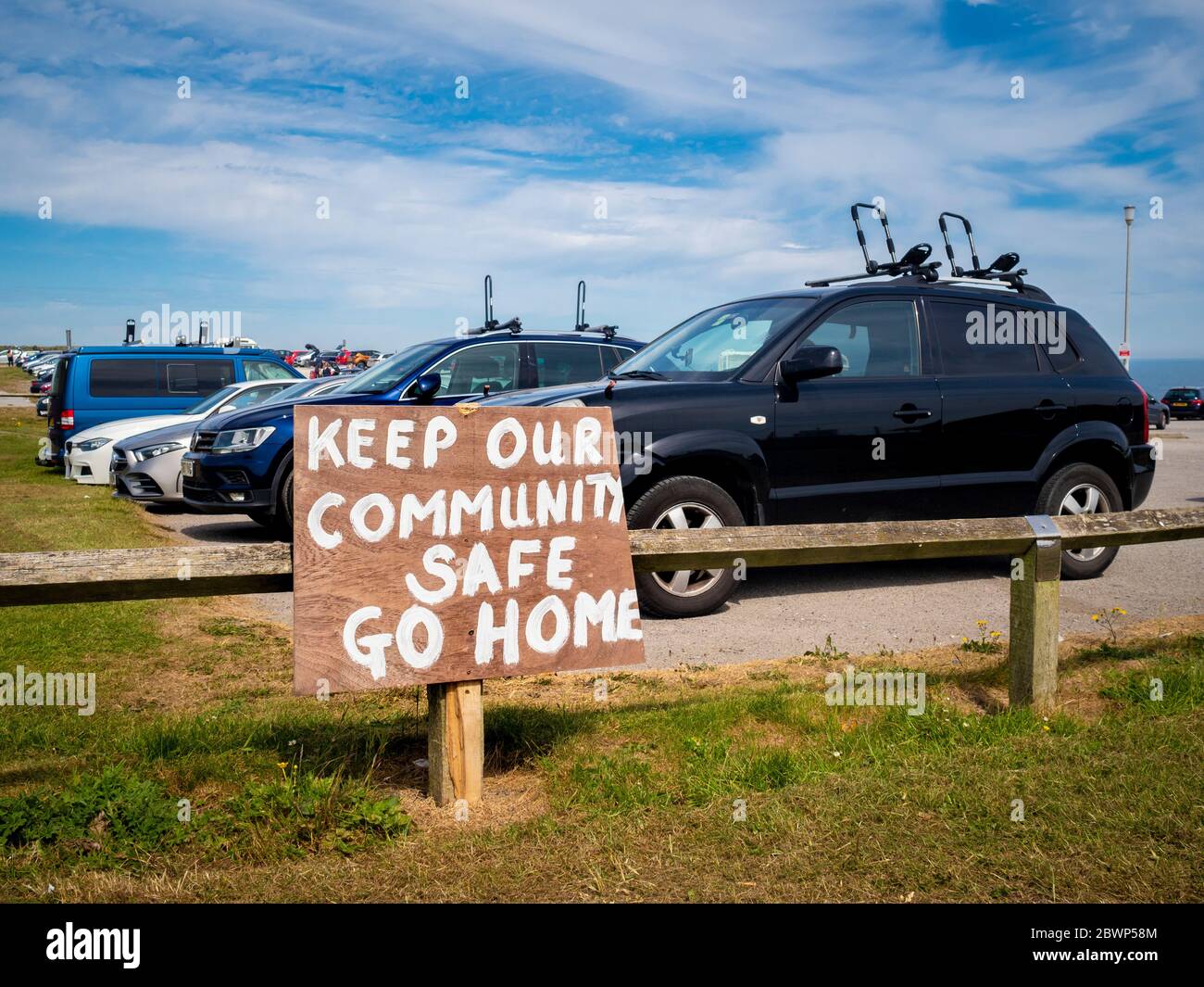 Gardez notre signe de sécurité de la communauté Go Home au parking, North Landing Bay, Yorkshire, Royaume-Uni. Banque D'Images