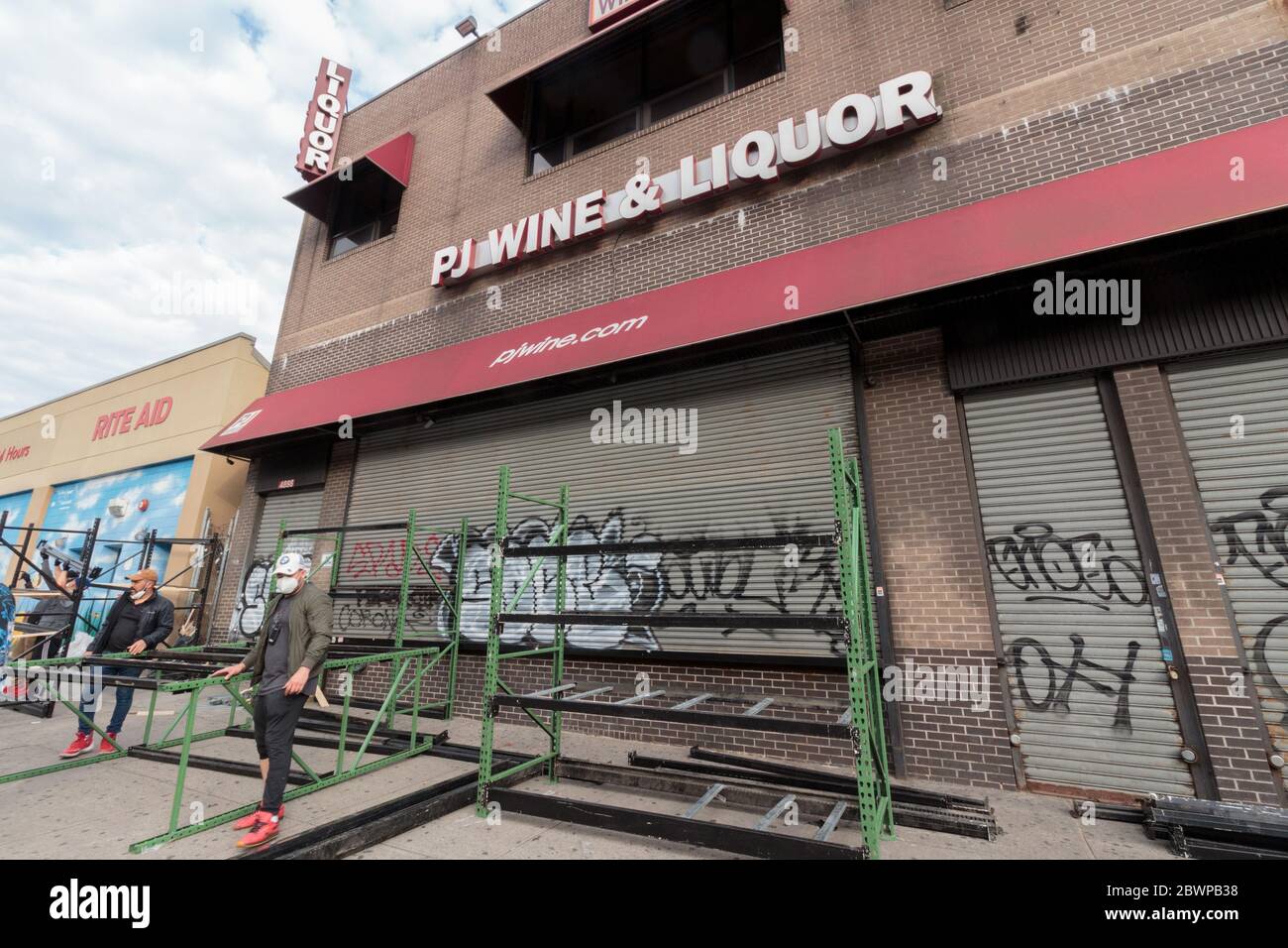 Inwood, NYC - des ouvriers en face de PJ Wine and Liquor Store dans construire une barricade pour protéger contre les pillages possibles lors de la fermeture tôt pour le couvre-feu Banque D'Images