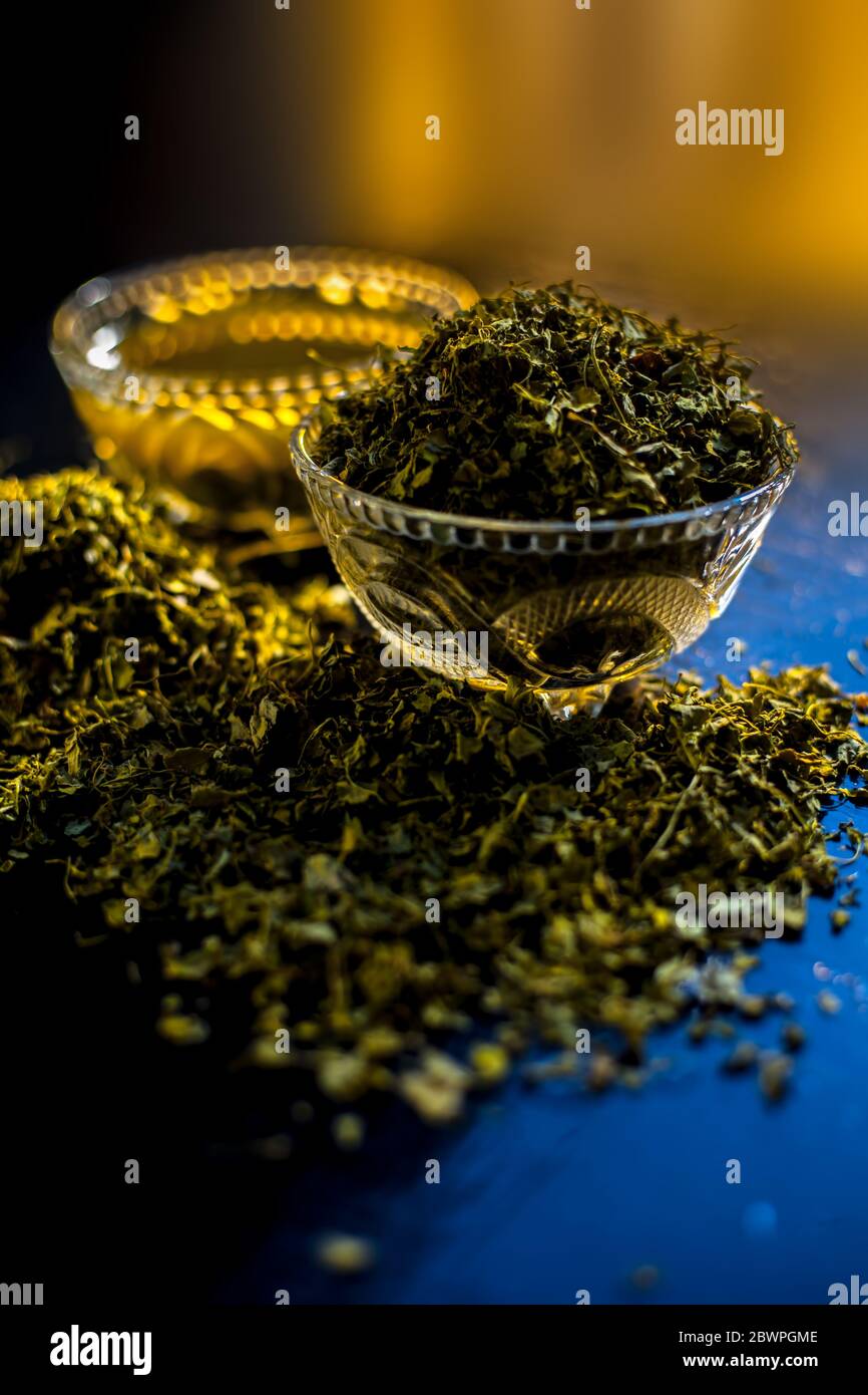 Prise de Kasuri methi cru et de sa pâte fraîchement préparée dans un bol en verre sur une surface noire brillante. Banque D'Images