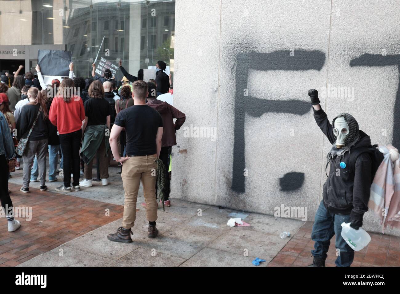 Un manifestant se tient devant un mur récemment graffiti devant le Justice Center, qui abrite la police de Cleveland, lors des manifestations à Cleveland, Ohio, États-Unis. Banque D'Images