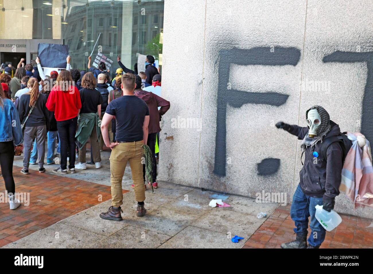 Un manifestant se tient devant un mur récemment graffié devant le Justice Center lors des manifestations à Cleveland, Ohio, États-Unis. Banque D'Images