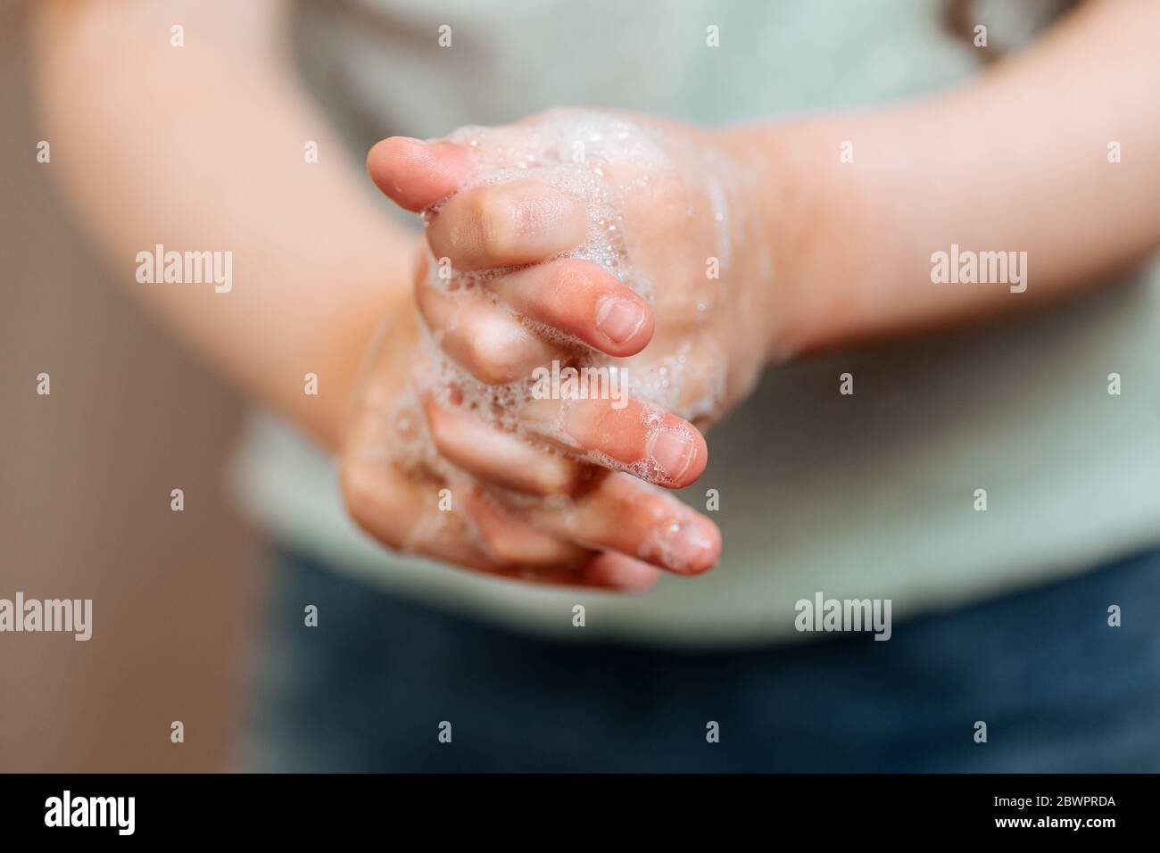 Mains d'enfants dans de la mousse savonneuse. Le concept de lavage des mains, d'hygiène. Banque D'Images