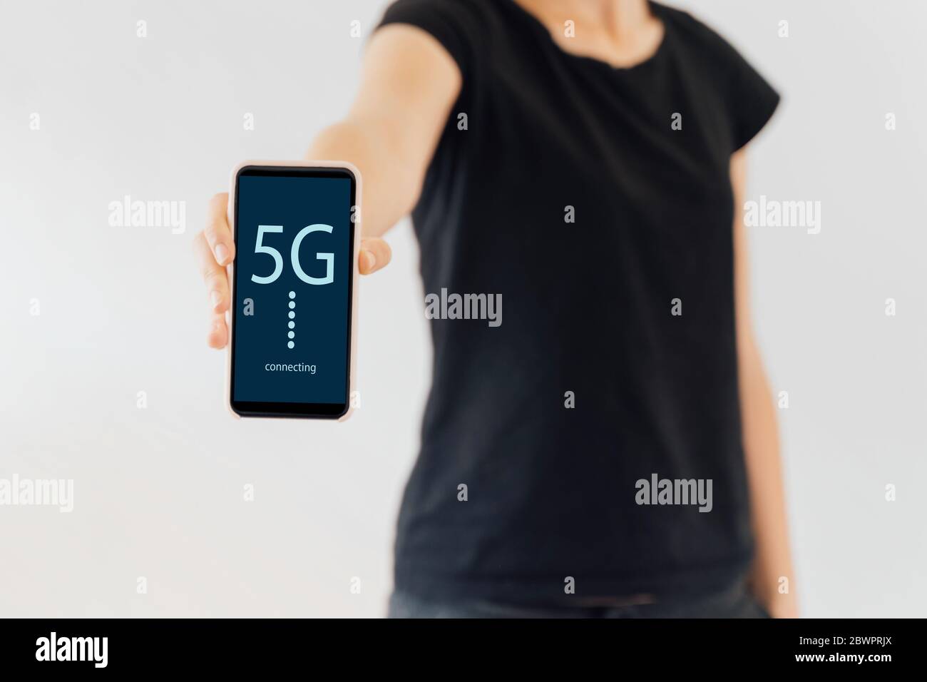 Femme utilisant un téléphone avec 5g de texte à l'écran. Réseau mobile rapide Banque D'Images