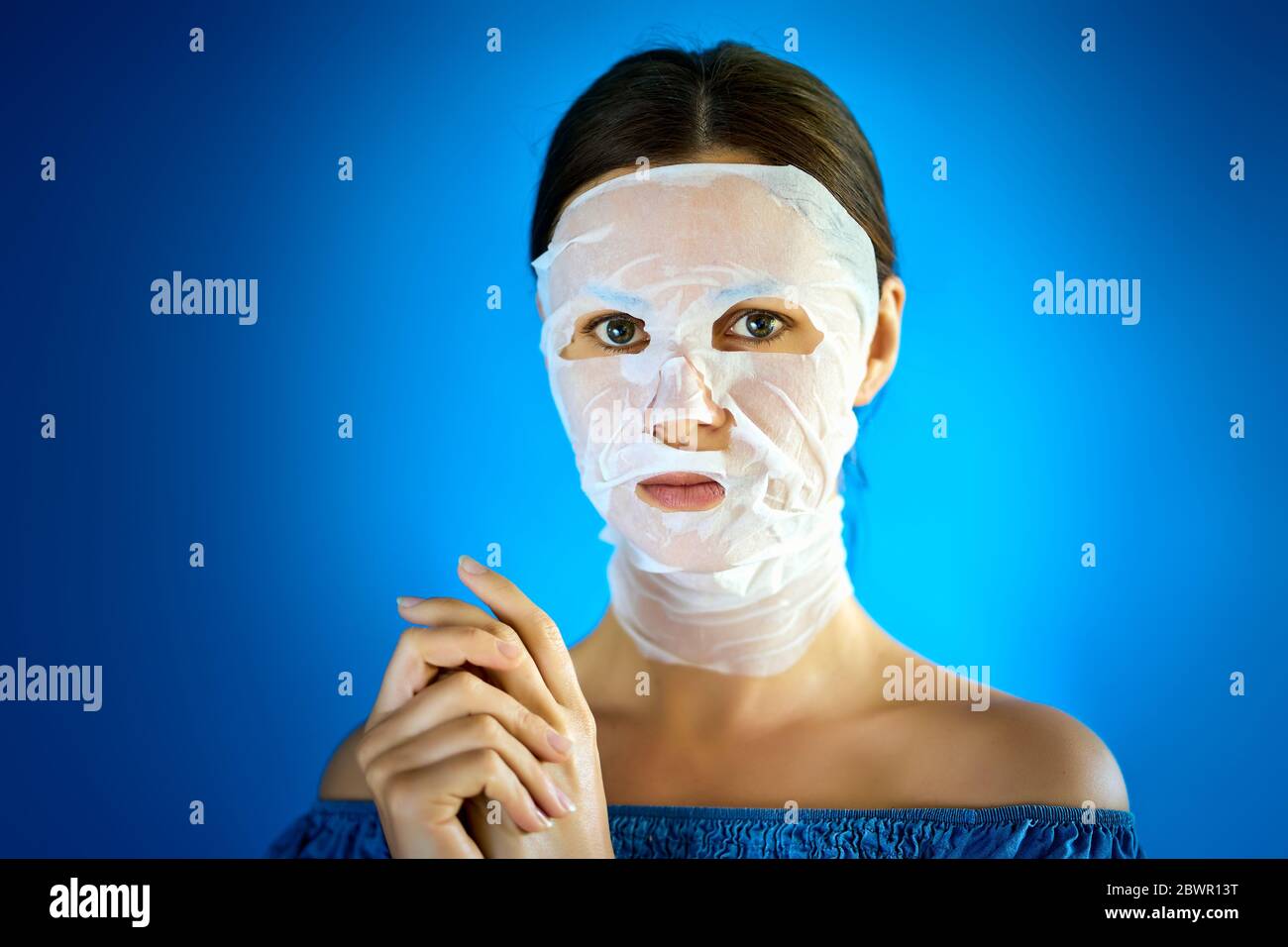 femme montre comment appliquer un masque de beauté à votre visage Banque D'Images