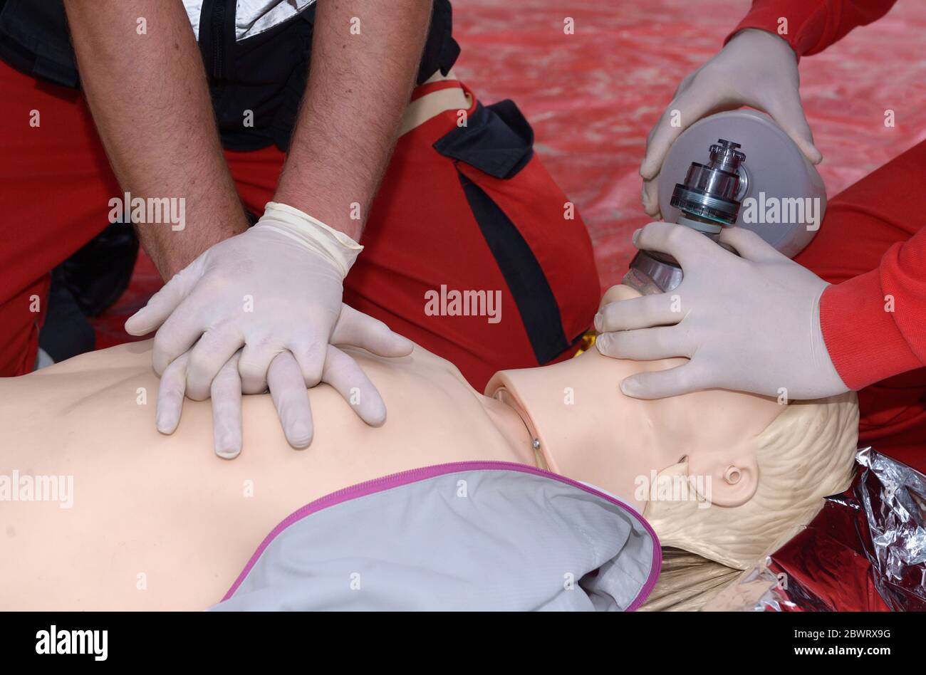 Travailleur d'urgence qui appuie sur la poitrine d'un patient, en gardant un coussin d'oxygène sur son visage. Respiration artificielle Banque D'Images