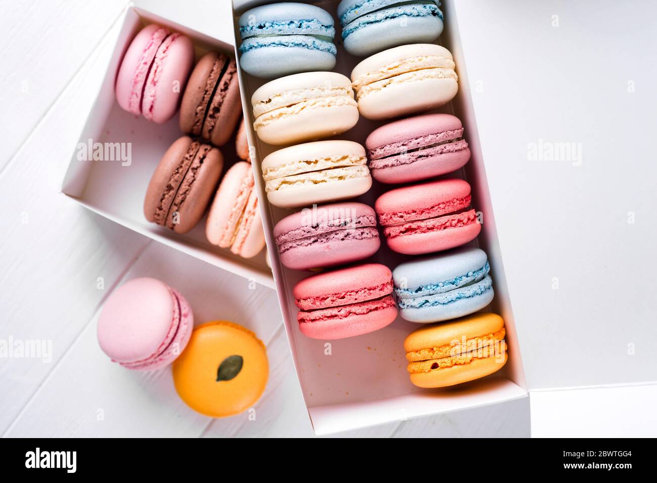 Macarons colorés sur la table en bois. Macarons sucrés en boîte cadeau. Télévision avec copie espace pour votre texte Banque D'Images