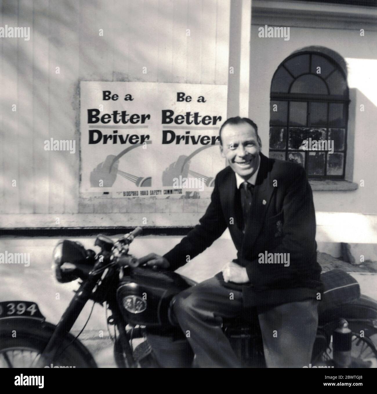 Moto AJS avec un homme d'âge moyen assis sur elle, années 1950 Banque D'Images