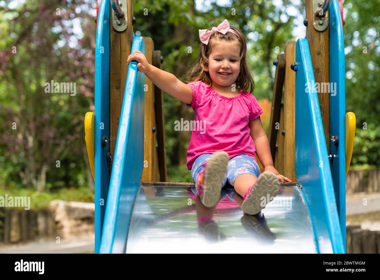 Portrait d'une petite fille souriante sur une glissade de jeu Banque D'Images