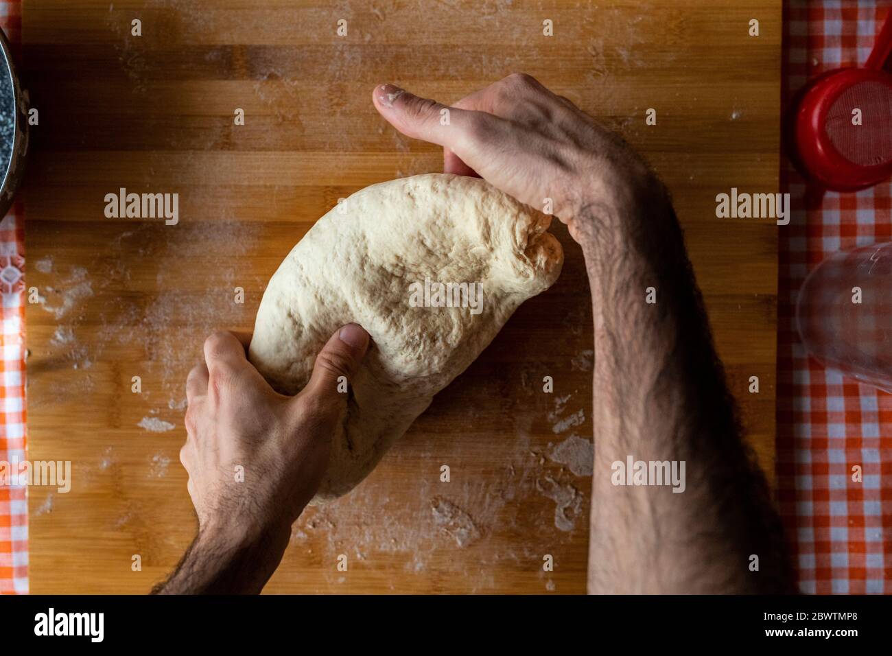 Mains d'homme pétrissant la pâte, vue de dessus Banque D'Images