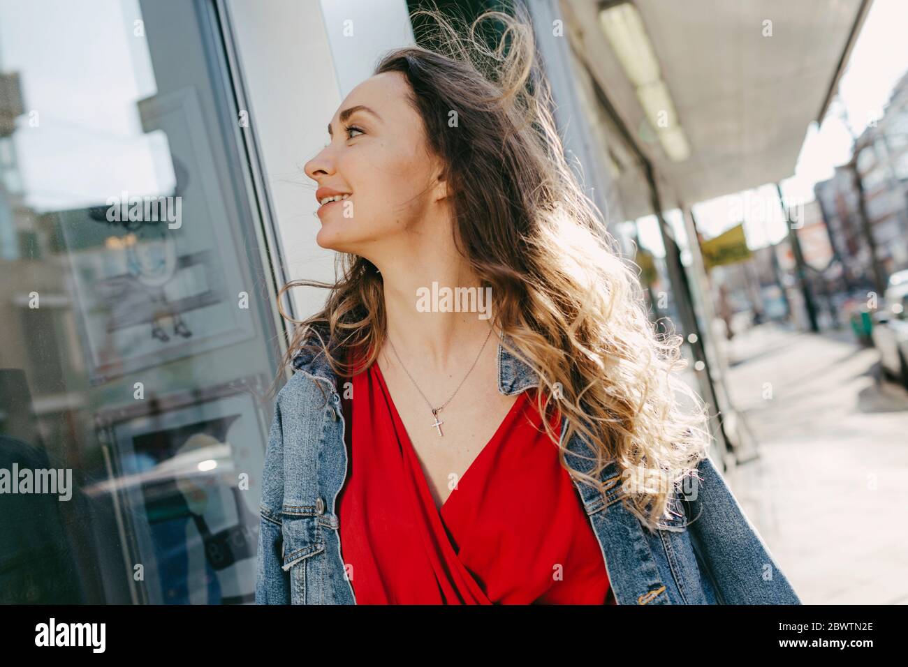 Femme regardant dans la fenêtre de magasin dans la ville Banque D'Images