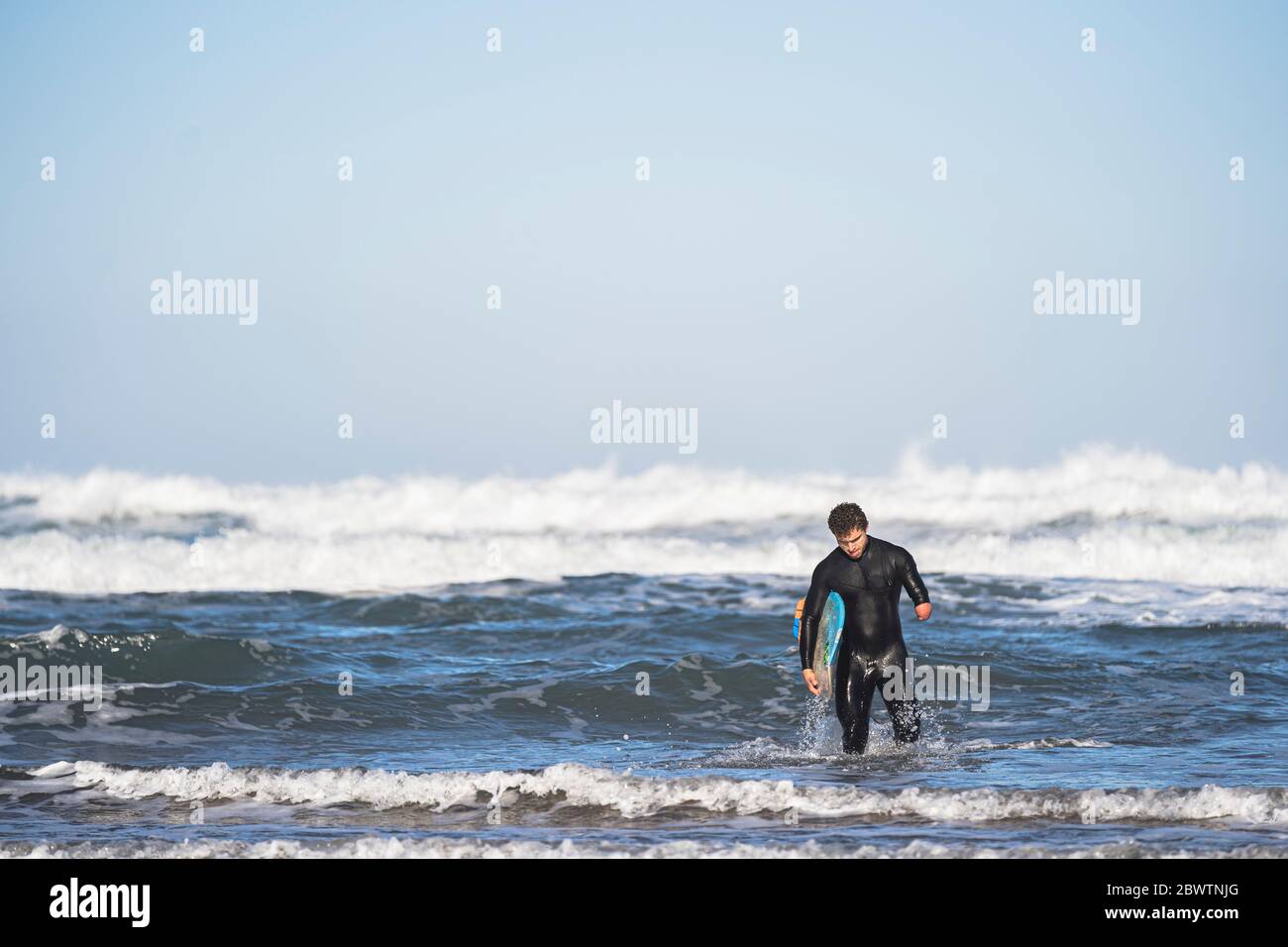 Surfeur handicapé avec planche de surf à la plage Banque D'Images