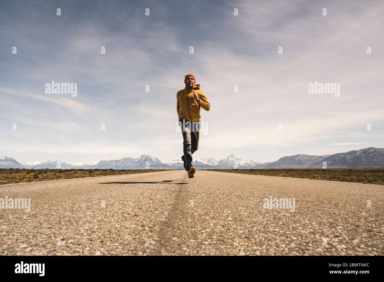 Homme qui court sur une route dans un paysage isolé en Patagonie, Argentine Banque D'Images