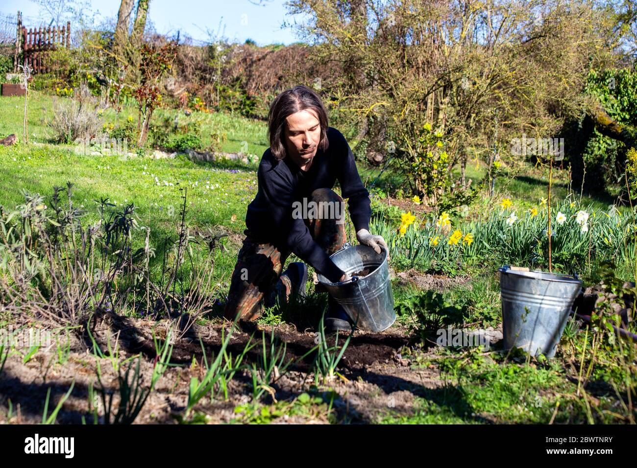 Homme travaillant dans un jardin biologique au printemps Banque D'Images