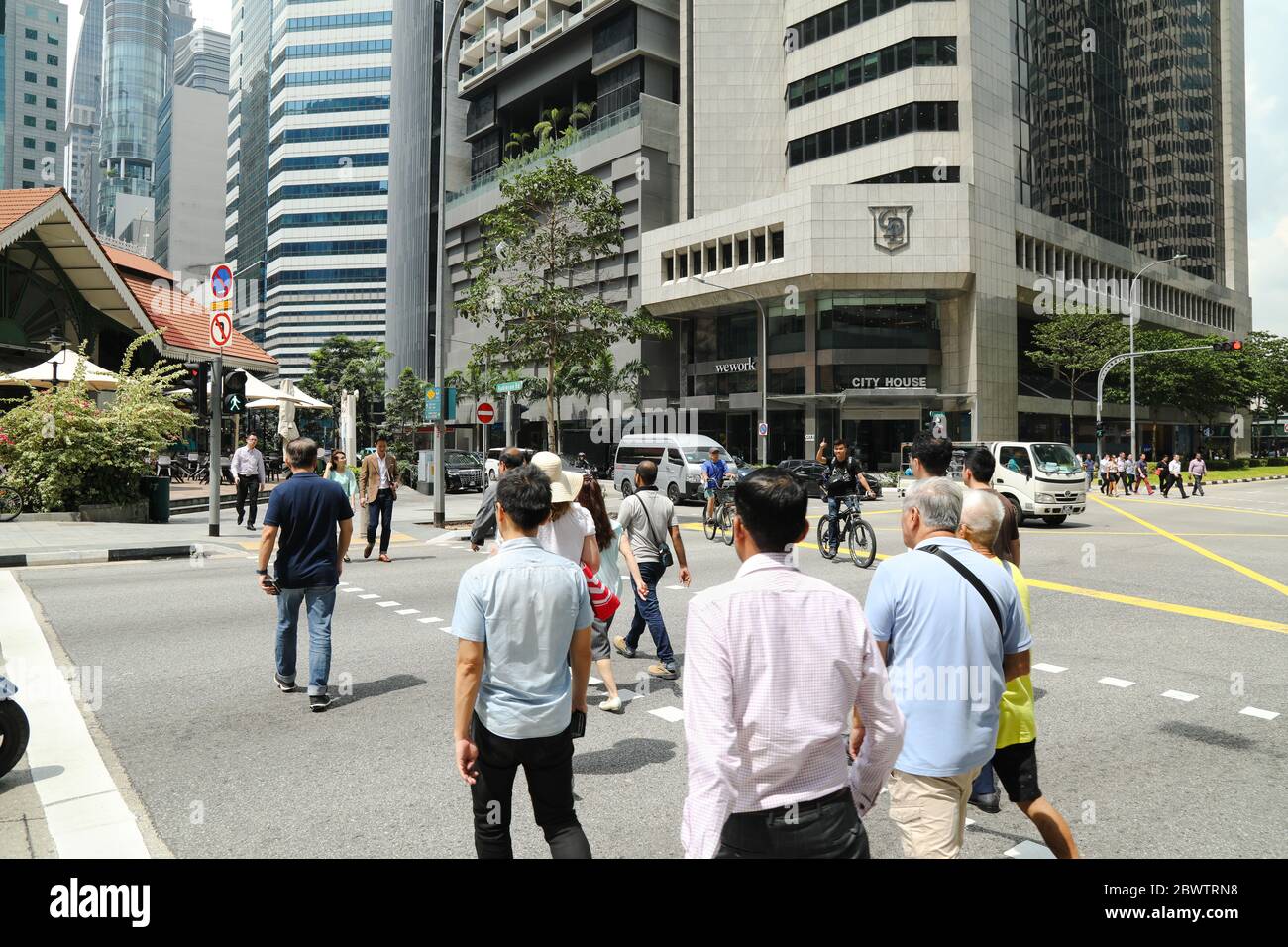 Les gens traversent une rue dans le quartier central des affaires de Singapour. Banque D'Images