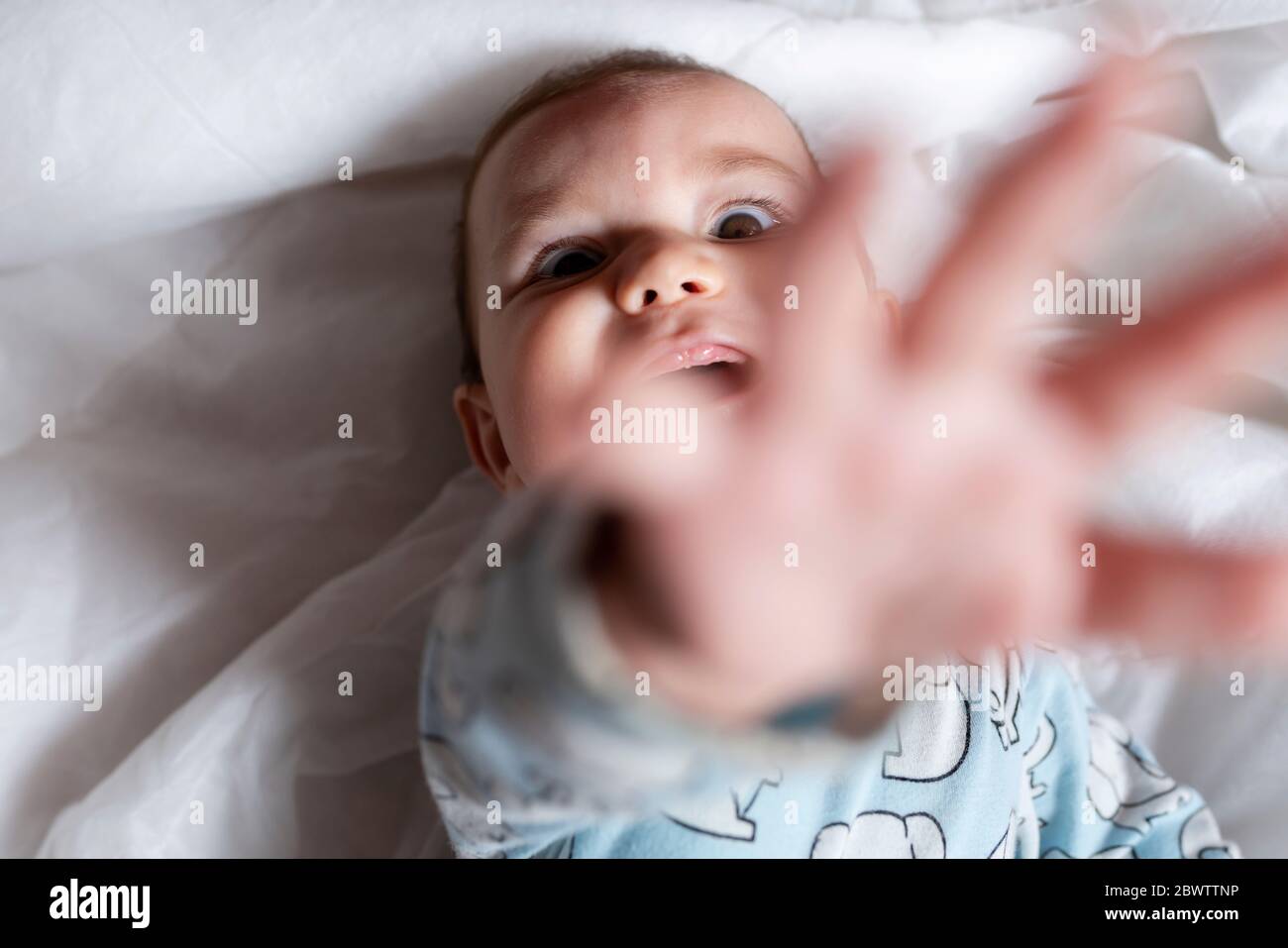 Baby girl teething, couché sur le lit Banque D'Images